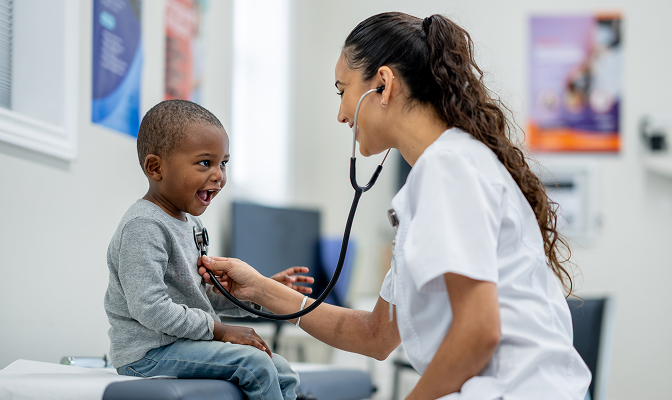 A doctor using a stethoscope on a young patient