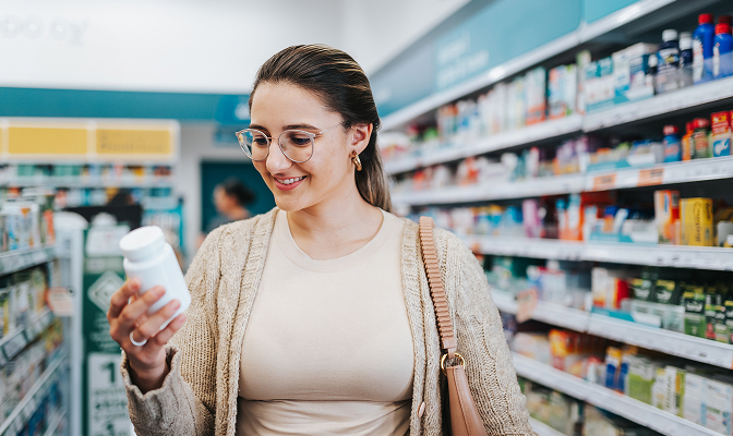 A woman with glasses shopping inside of a pharmacy