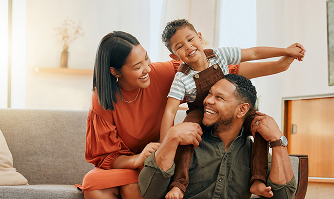 A father, mother, and son playing together in their living room