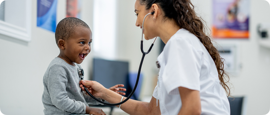 A nurse checking her child patient's heartbeat with a stethoscope