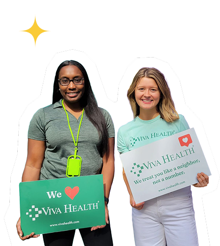 Two Viva Health employees holding Viva Health signs and smiling